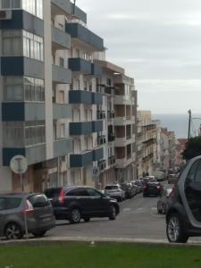 a parking lot with cars parked in front of a building at Apartamento Blue dream in Sesimbra