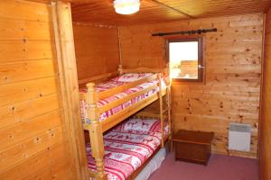 a bedroom with two bunk beds in a log cabin at Grand Chalet 15 personnes. Vue exceptionnelle . Plein sud in Allos