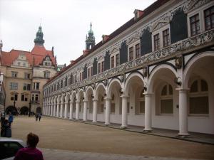 a large building with white columns in a courtyard at Dresden-Fewo-Huhle in Obernaundorf