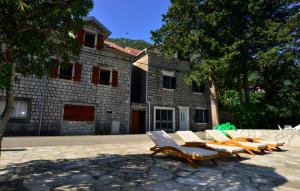 a group of lounge chairs in front of a building at A Hundred Olive Trees Apartments in Kotor