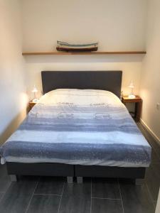 a bedroom with a bed with a blue comforter at Cosy Harlingen I in Harlingen