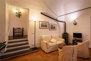 オルヴィエートにあるAppartamento LaRosaのリビングルーム(椅子、テレビ付)、階段