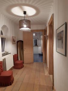 ein Wohnzimmer mit Holzboden und einem Kronleuchter in der Unterkunft La Maison du Maître in Dinant