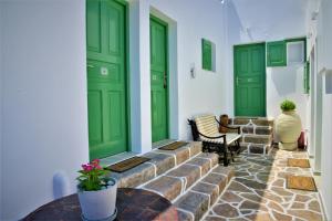 une chambre avec des portes vertes et une personne assise dans une chaise dans l'établissement Dioni lux inn, à Pachaina