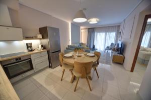 a kitchen and living room with a table and chairs at Onar Modern Luxury Apartments in Kavala
