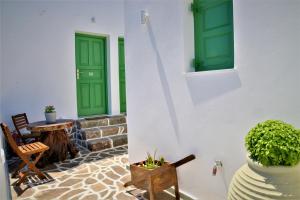 a patio with green doors and a table and chairs at Dioni lux inn in Pachaina