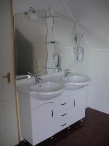 a bathroom with two sinks and a large mirror at Paks Panzió in Paks