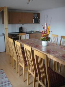 cocina con mesa de madera grande con sillas y encimera en Paks Panzió en Paks