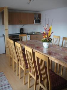 a kitchen with a large wooden table with chairs and a counter top at Paks Panzió in Paks