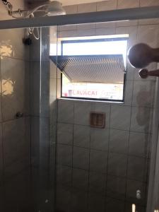 a bathroom with a glass shower with a window at Carol Palace Hotel in Foz do Iguaçu