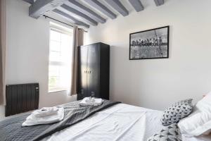 a bedroom with a bed and a large window at La Dimiere - Le Postel - Appartements de standing en hyper-centre - Louviers in Louviers