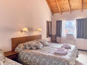 1 dormitorio con 1 cama con 2 toallas en Hotel Cumbres Nevadas en El Chaltén