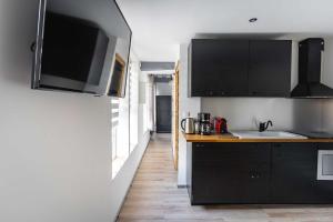 una cucina con armadi neri e lavandino di La Dimiere - Le Postel - Appartements de standing en hyper-centre - Louviers a Louviers