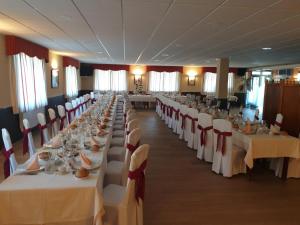 a large banquet hall with white tables and chairs at Complejo O Piñeiral A Fonsagrada in Fonsagrada