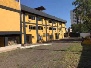 een lege straat voor een geel gebouw bij Carol Palace Hotel in Foz do Iguaçu