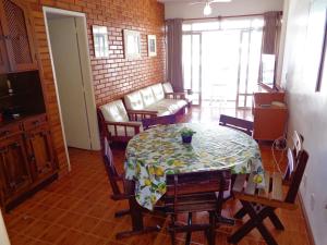 uma sala de jantar com uma mesa e cadeiras e um sofá em Apartamento praia do forte em Cabo Frio