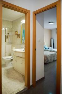 a bathroom with a sink and a toilet and a bed at Bonito apartament a 3 minutos de la playa in Cullera