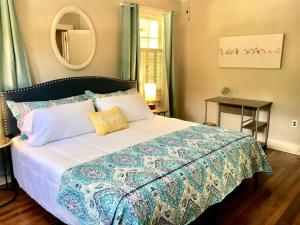a bedroom with a large bed with a mirror at KING BED Family Friendly Cottage - Walk to Zoo & Waterpark - Near Downtown & Midtown in Hattiesburg