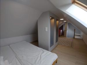 a bedroom with a white bed and a staircase at Apartament Dorota z garażem in Szklarska Poręba