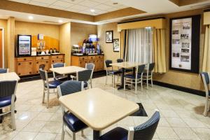 a restaurant with tables and chairs and a counter at Holiday Inn Express Charlotte West - Gastonia, an IHG Hotel in Gastonia