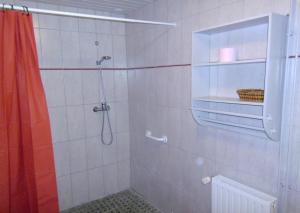un bagno con doccia con tenda da doccia di Au Jardin Des Violettes a Mahéru