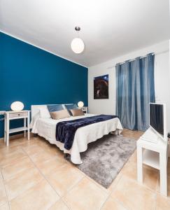 sypialnia z łóżkiem i niebieską ścianą w obiekcie Luxury Suite Sea Front w mieście Playa Honda