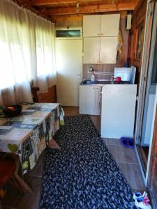 a small kitchen with a table and a refrigerator at Perucac Jezero in Perućac