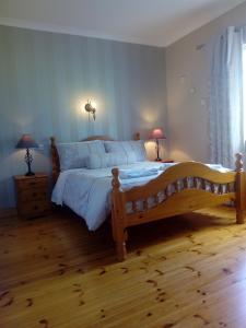 1 dormitorio con 1 cama grande y 2 lámparas en las mesas en Inny River Lodge, en Rathowen