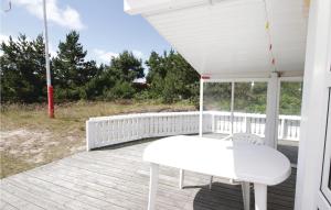 a white table and chair on the porch of a house at Holiday Home Hvide Sande 48 in Bjerregård