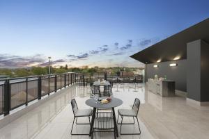 a patio with tables and chairs on a balcony at Quest Orange in Orange