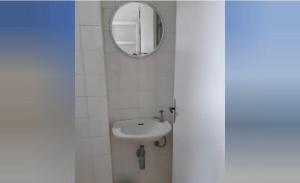 a bathroom with a sink and a mirror at Pé na Areia in Arraial do Cabo