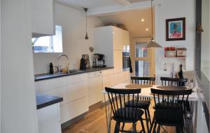 a kitchen with a table and some chairs in it at Five-Bedroom Holiday Home In Otterup in Otterup