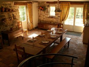 a dining room with a table and chairs and windows at La Trainelière in Les Épesses