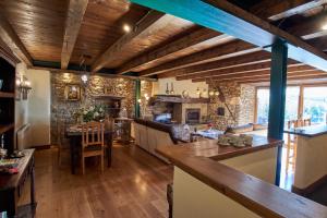 una gran cocina con techos de madera y una pared de piedra. en Apartamentos Solsalient, en Vilach