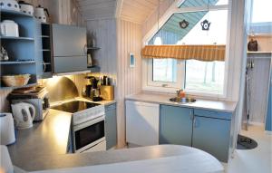 una pequeña cocina con armarios azules y fregadero en Stunning Home In Asperup With Wifi, en Asperup