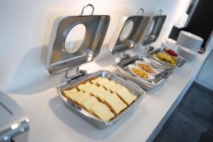 a row of trays of food on a counter at Hotel Zam 101 in Busan