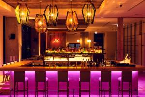 a bar in a restaurant with purple lighting at Hotel It Osaka Shinmachi in Osaka