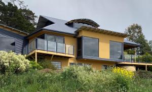 une maison jaune avec beaucoup de fenêtres dans l'établissement Convict Beach Coastal Retreat, à Saltwater River