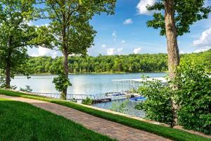 a dock on a lake with trees at Chalets Resort Luxury Lakefront Villa Family Friendly 2 Pools Free Amenities in Lampe