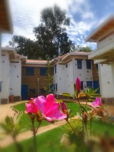 萊瓦鎮的住宿－HOTEL & CABAÑAS CASHILUNA，一群粉红色的花在一座建筑前