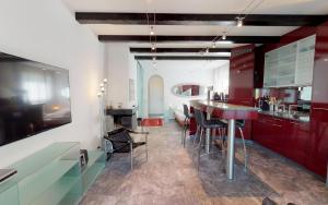 サンモリッツにあるAllegria 16のキッチン(赤いキャビネット、テーブル、椅子付)