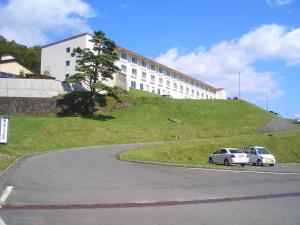 two cars parked in front of a building on a hill at Kyukamura Iwate-Amiharionsen in Shizukuishi