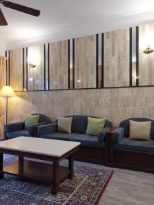 Sala de estar con 2 sofás y mesa de centro en Hills Sanctuary Retreat, B7-3A-2 with WI-FI, en Bukit Fraser