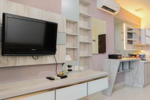 ein Wohnzimmer mit einem Fernseher an der Wand in der Unterkunft Cozy 1BR Apartment at Brooklyn Alam Sutera near IKEA By Travelio in Dongkal Dua