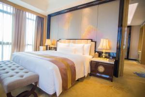 a bedroom with a large bed and a large window at Wanda Vista Quanzhou in Quanzhou