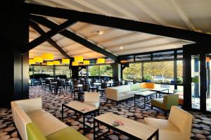 een restaurant met banken, tafels en stoelen bij Relais Fasthotel Port Lauragais in Avignonet-de-Lauragais