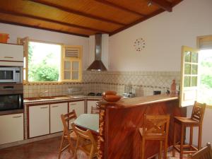 a kitchen with a table and some chairs in it at RESIDENCE LA TAUPINE MANDARINE in Le Diamant +27 photos