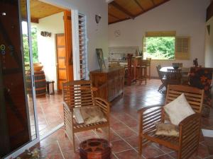 Una sala de estar con sillas y un comedor. en RESIDENCE LA TAUPINE MANDARINE, en Le Diamant