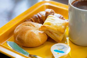 a tray with a plate of pastries and a cup of coffee at Hotel Wing International Shimbashi Onarimon in Tokyo