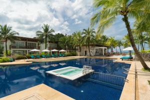 a swimming pool with palm trees and a resort at The Briza Beach Resort, Khao Lak SHA Extra Plus in Khao Lak